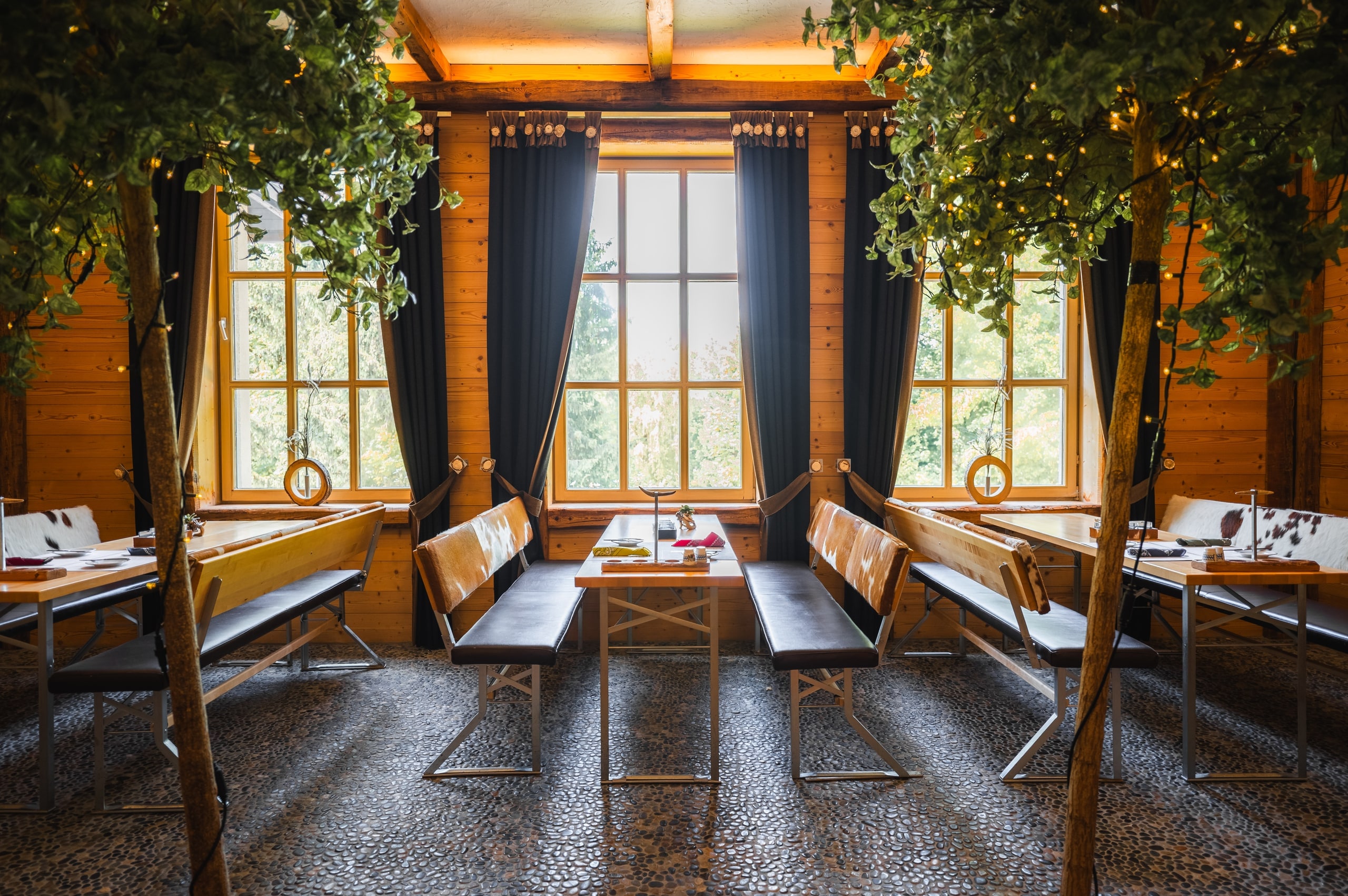 Zweite Ansicht des Indoor-Biergartens mit Schankbereich und Sitzreihen