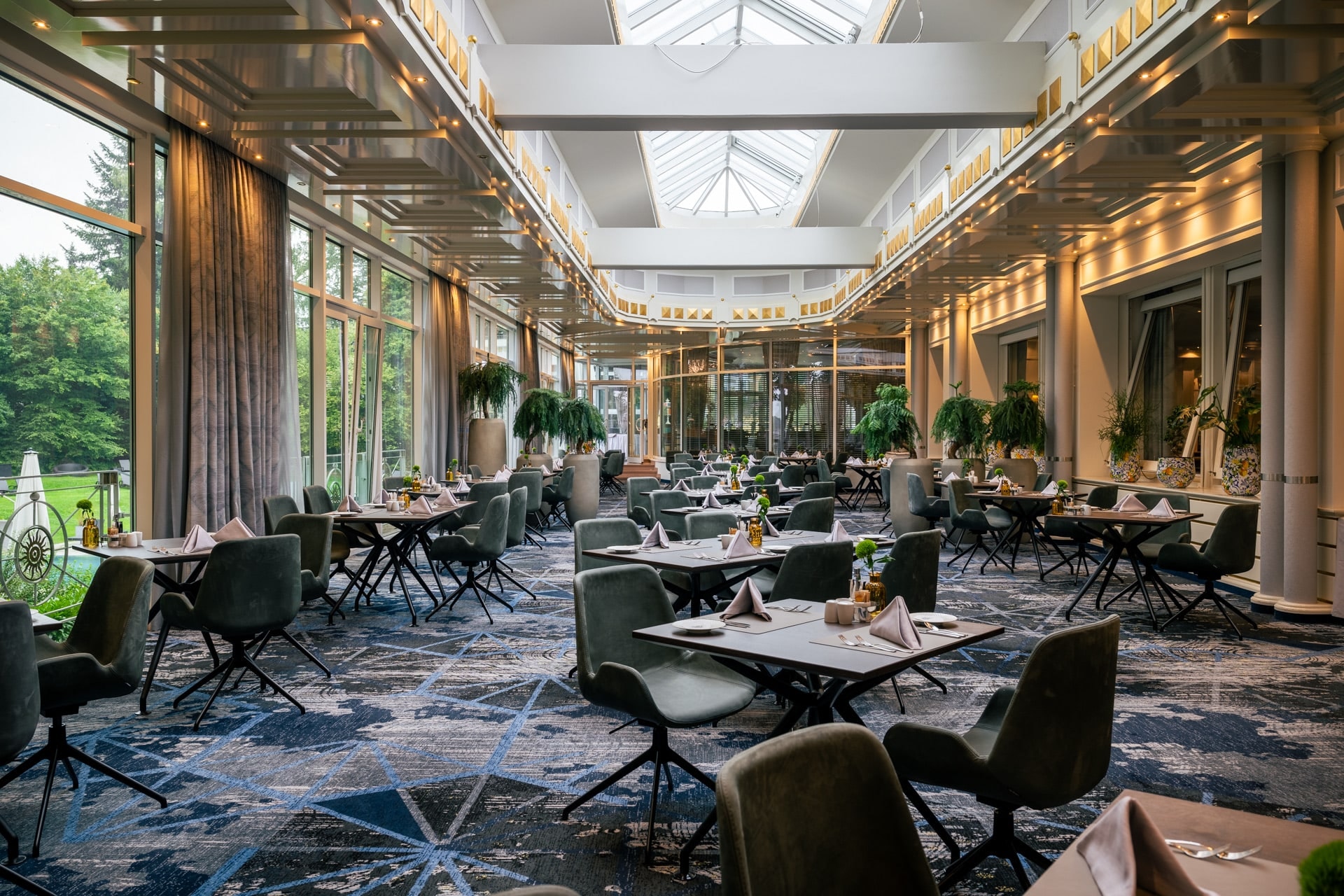 Der lichtdurchflutete Wintergarten im INSPIRA Sonnenhof mit Blick in den Hotelpark