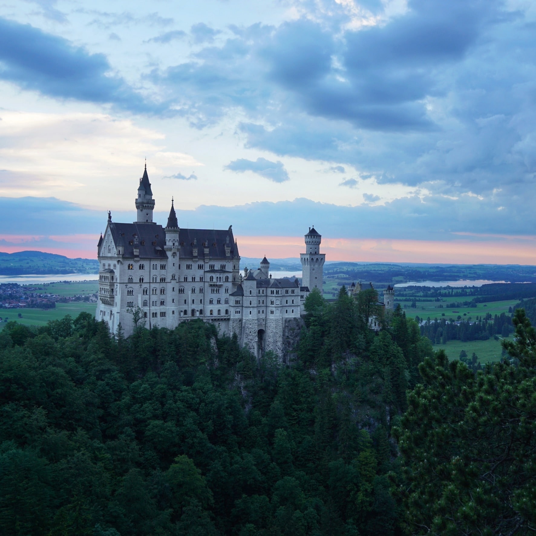 Schloss Neuschwanstein über bewaldeten Hügeln bei Füssen