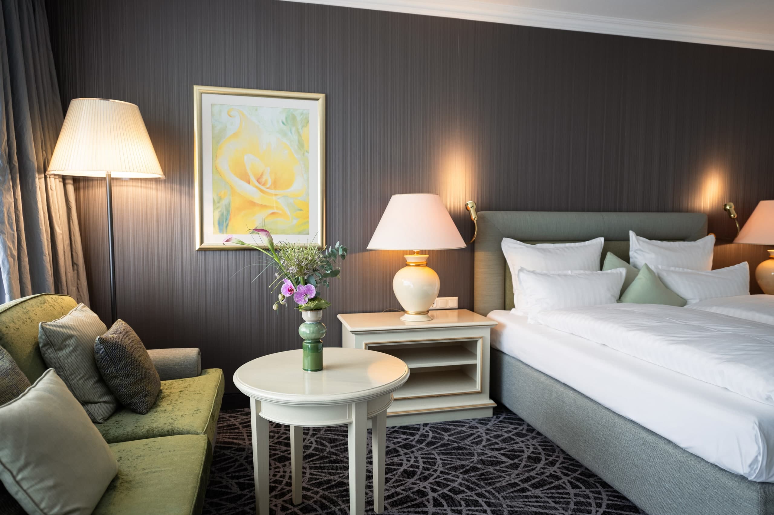 Zimmer im Hotel Der Sonnenhof mit Doppelbett, Sitzecke und warmem Nachtlicht